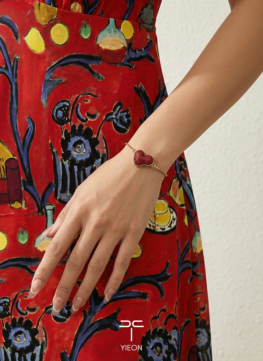 Matisse’s Red Fantasy: a red silk gourd motif on a gold-toned bracelet chain; worn view.