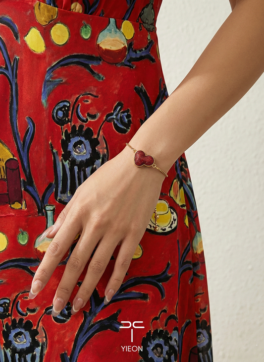 Matisse’s Red Fantasy: a red silk gourd motif on a gold-toned bracelet chain; worn view.